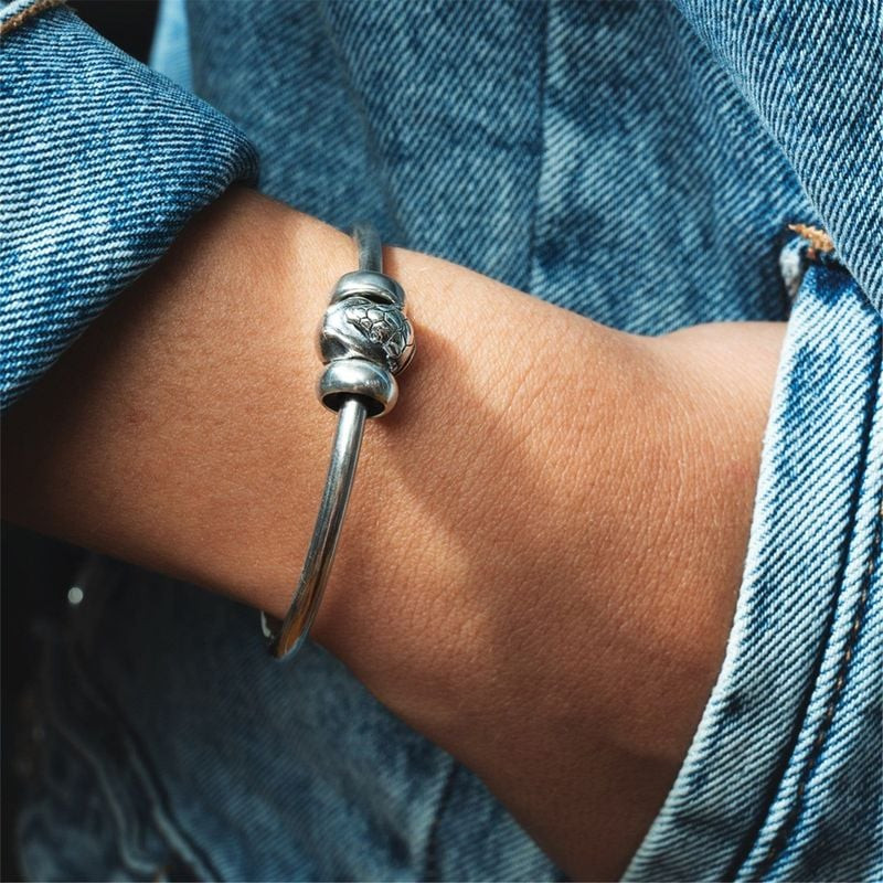 Une personne portant un bracelet Trollbeads avec le charme TROLLBEADS PERLE TATOU ARGENT