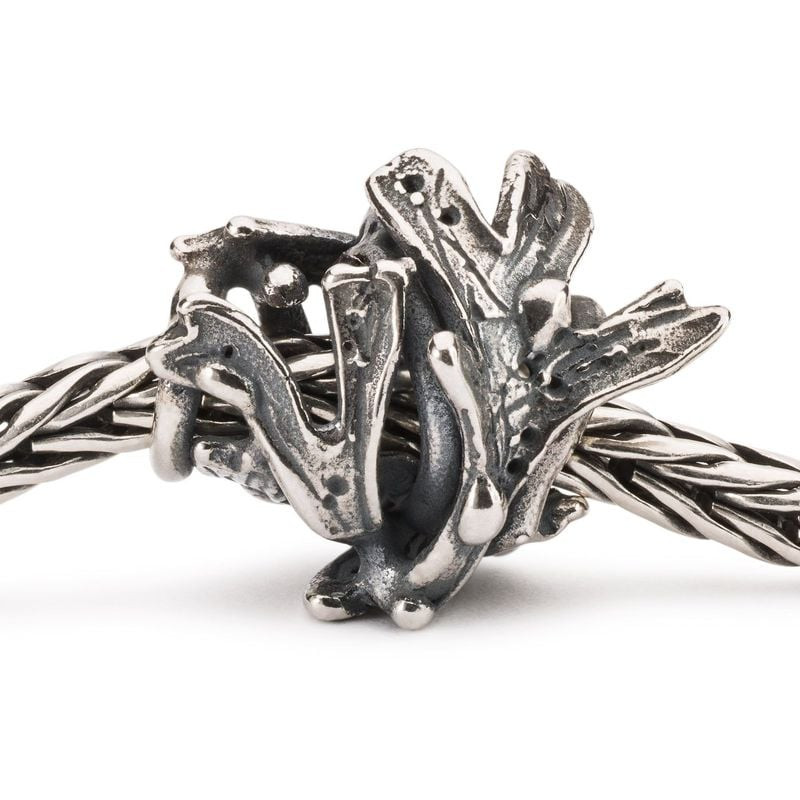 Gros plan de la perle de charme TROLLBEADS ALGUE ARGENTÉ enfilée sur une chaîne de bracelet en argen