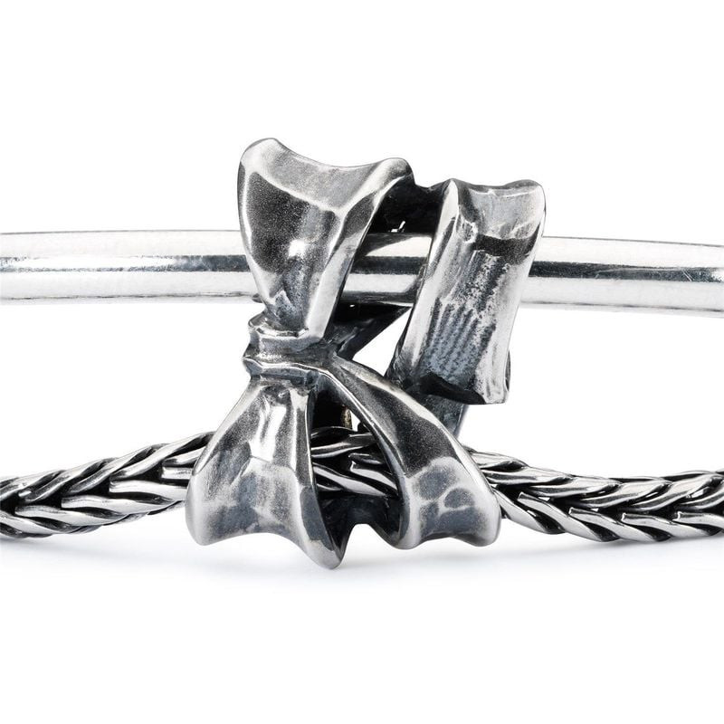 Perle Trollbeads Nœud Double Argenté en argent sterling, présentée sur un bracelet en cuir dans une 