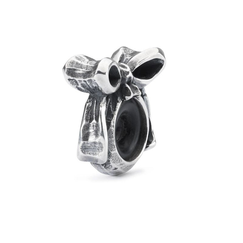 Vue de côté de l'espaceur argenté Trollbeads Nœud, boucles ruban et ouverture noire pour bracelet
