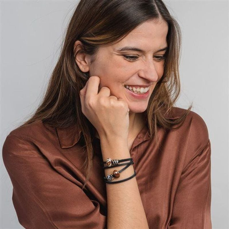 Perle Trollbeads Trois Frères Sœurs Argenté portée sur bracelet, ambiance lifestyle élégante.