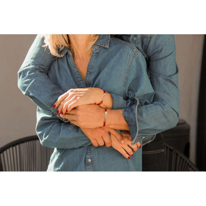 Couple enlacé en chemises en jean, portant tous deux le bracelet Osmose en paracorde rouge et anneau