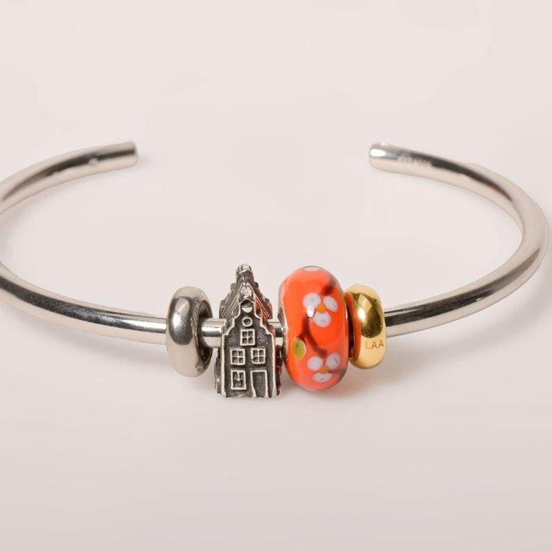 Perle de charme Trollbeads Maison de canal argenté exposée dans une ambiance chaleureuse et élégante