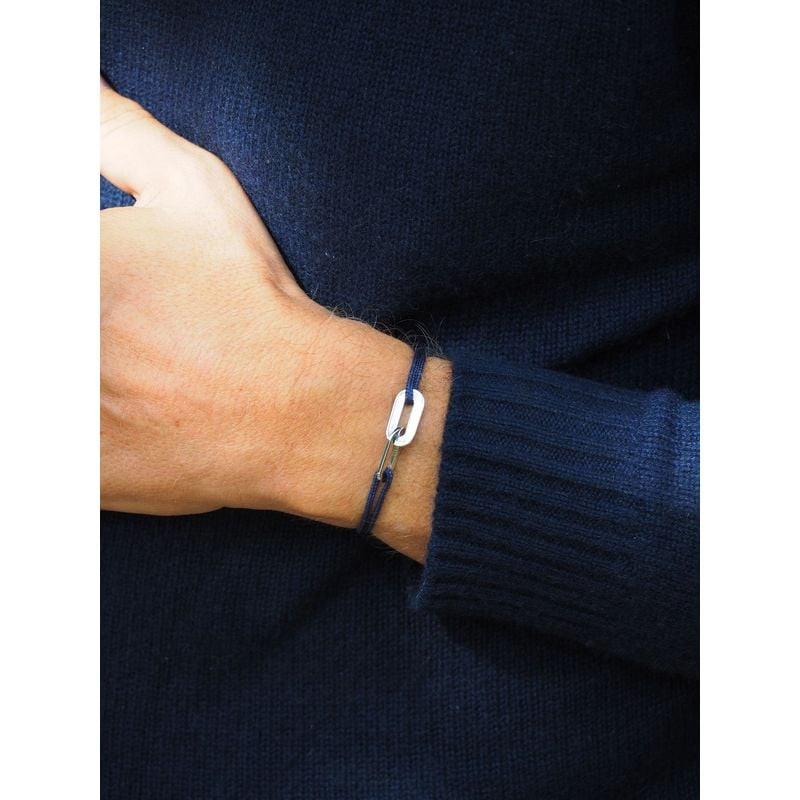 Bracelet double anneaux argenté sur cordon bleu marine porté au poignet sur un pull en maille marine