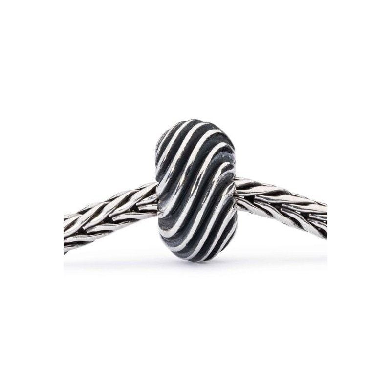 Perle Trollbeads Douce vague en argent, motif vague, enfilée sur un bracelet tressé Trollbeads