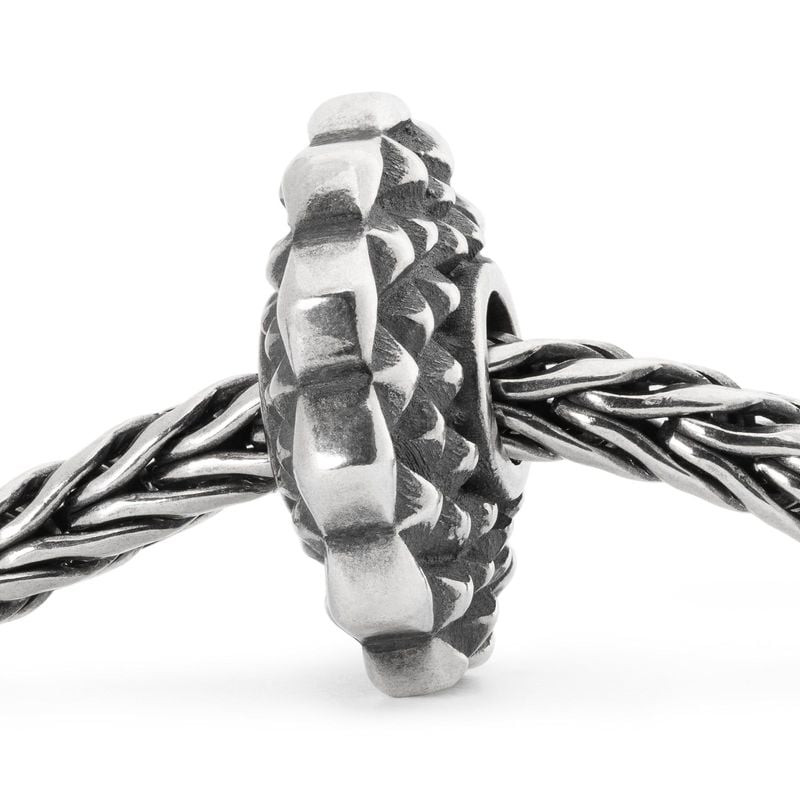 Perle Trollbeads Kaléidoscope argentée enfilée sur un bracelet tressé Trollbeads, vue de côté des fa