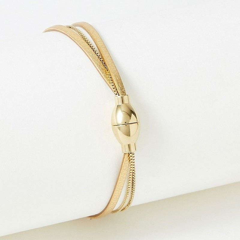 Gros plan du bracelet Nolah montrant le fermoir ovale doré poli et le lien en cuir doré avec chaîne 