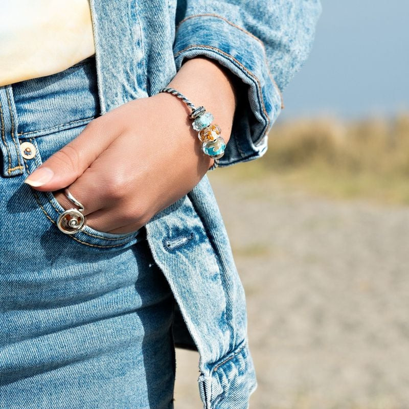 Image lifestyle de l'Écarteur Trollbeads Bisou du Dauphin Argenté porté sur un bracelet en argent.