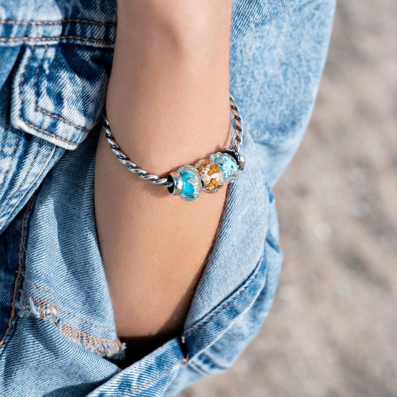 Écarteur Trollbeads Bisou du Dauphin Argenté sur un bracelet, gros plan sur le design des dauphins.