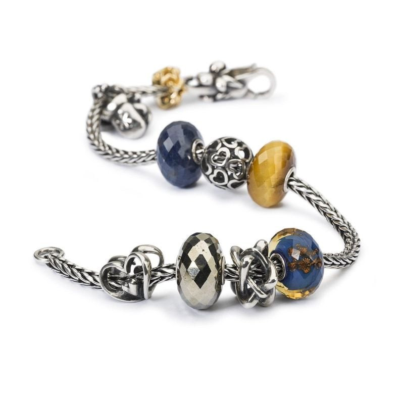 Bracelet Trollbeads orné d'une perle nœud, de perles en verre bleu et ambre et de charms en argent