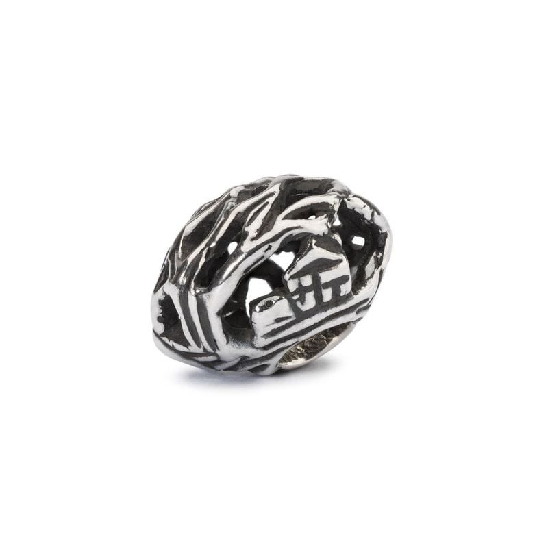Gros plan de la perle Trollbeads Étendue sauvage en argent, avec une maison miniature cachée dans so