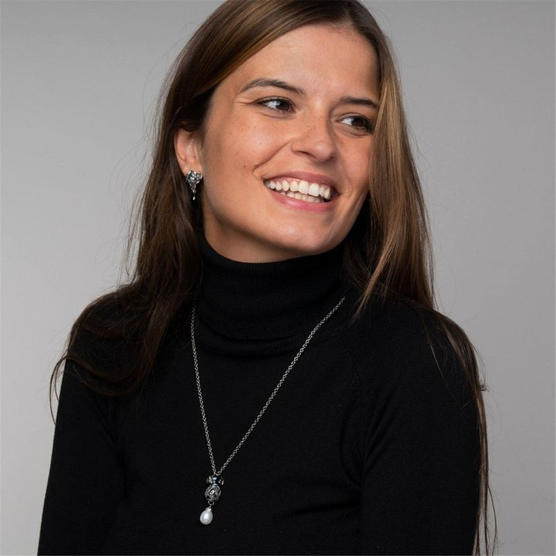 Femme souriante en col roulé noir portant le collier perle Trollbeads Étendue sauvage argentée