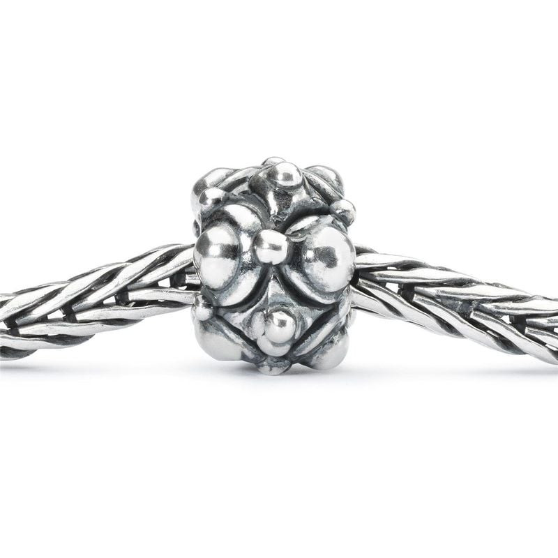 Perle argentée Trollbeads Chemin cahoteux enfilée sur un bracelet Trollbeads tressé en gros plan