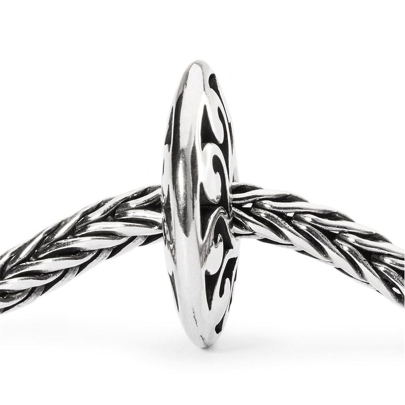 Breloque Trollbeads Lueur du jour en argent vue de profil sur un bracelet tressé Trollbeads