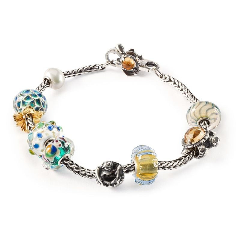 Un bracelet Trollbeads orné de la perle tortue Long Life Bead et de diverses autres perles décorativ