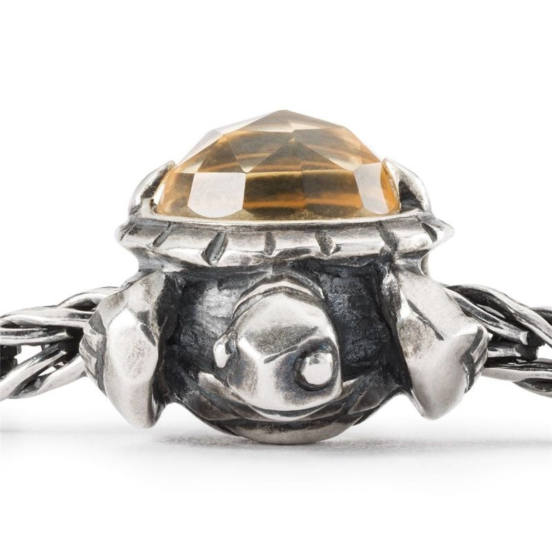 Gros plan sur la perle Long Life de TROLLBEADS, dévoilant les détails de la tortue en argent et sa c