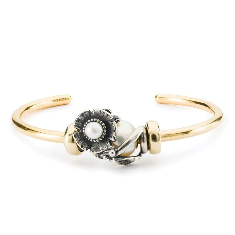 Perle Trollbeads Fleur Argenté en argent 925 avec perle nacrée, posée sur un fond élégant.