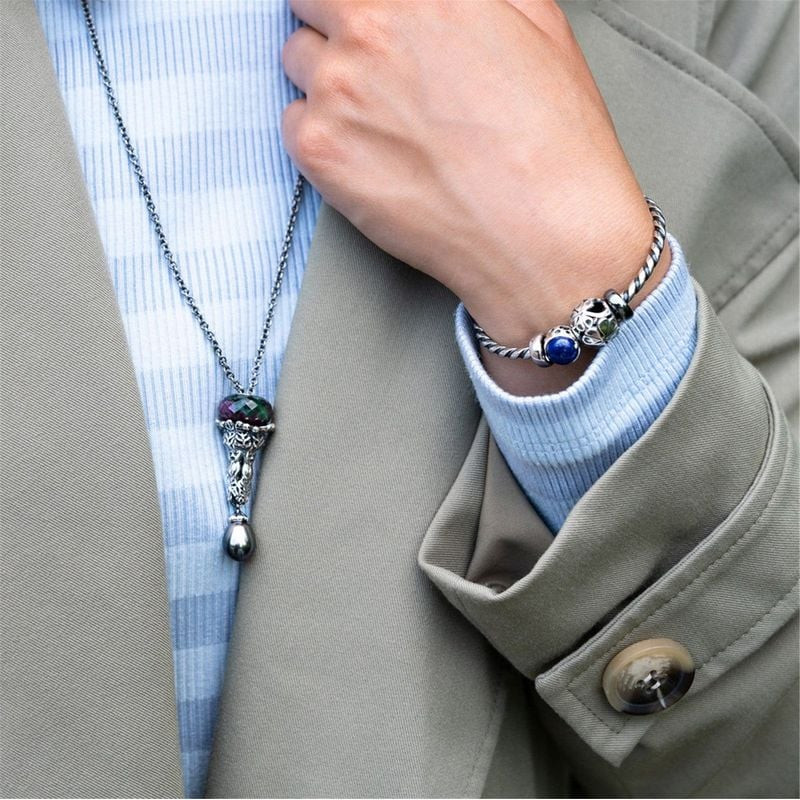 Personne portant un bracelet Trollbeads avec la perle Berceau de la Connaissance et un collier.