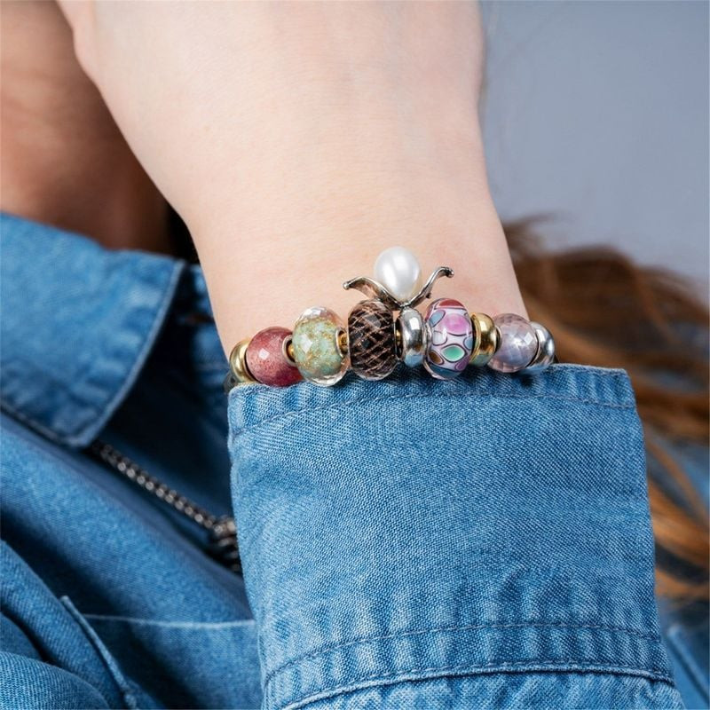 Image lifestyle d'un arrêtoir Trollbeads Perle Fleurie sur un poignet avec chemise en jean