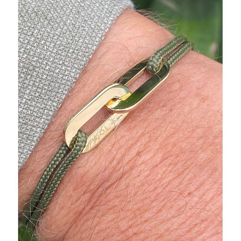 Gros plan sur un poignet à manche grise portant le bracelet Jean-Jean avec double anneaux dorés sur 