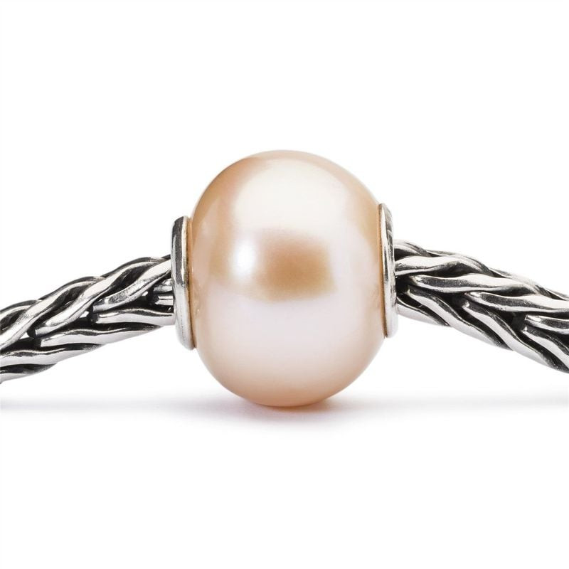 Gros plan sur la perle rose Trollbeads en perle de culture enfilée sur une chaîne Trollbeads en arge