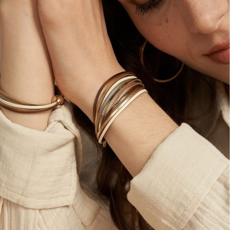 Femme portant le bracelet Malicieux My Way T1 au poignet avec une tenue en lin beige et des créoles