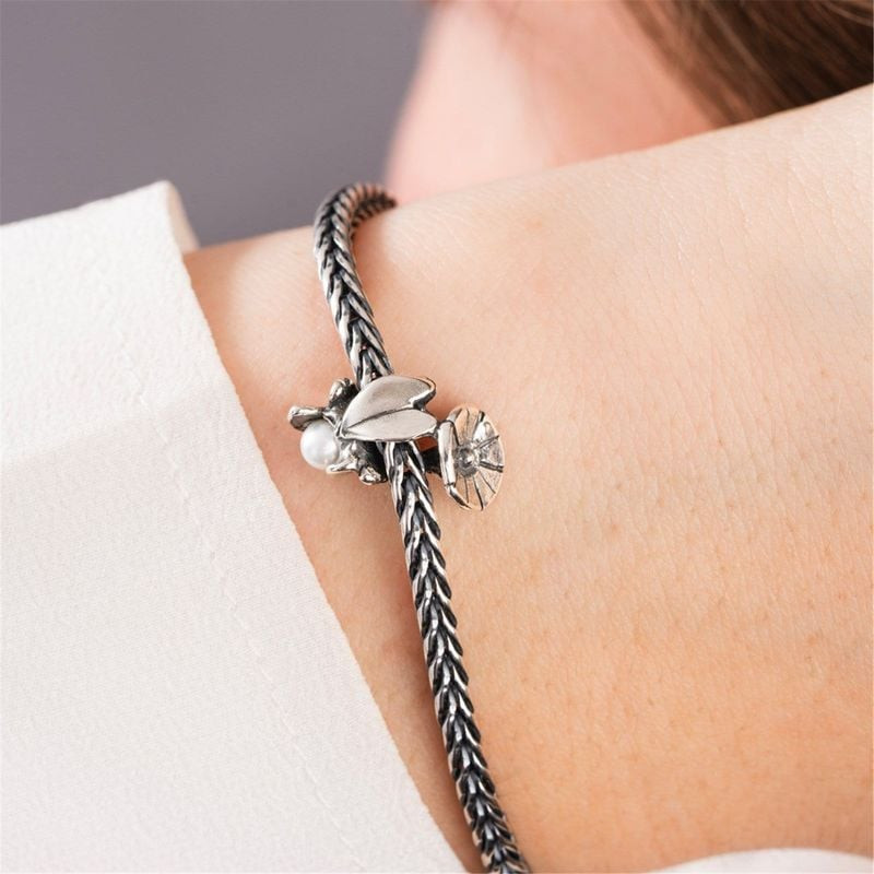 Charm Trollbeads Liseron de Septembre Argenté sur un bracelet, avec perle de culture d'eau douce