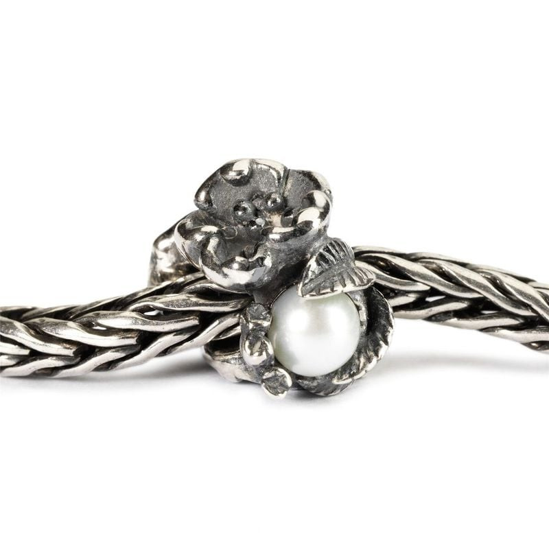 Breloque Trollbeads Nerprun de mai fixée sur un bracelet chaîne Trollbeads en argent, illustrant sa 