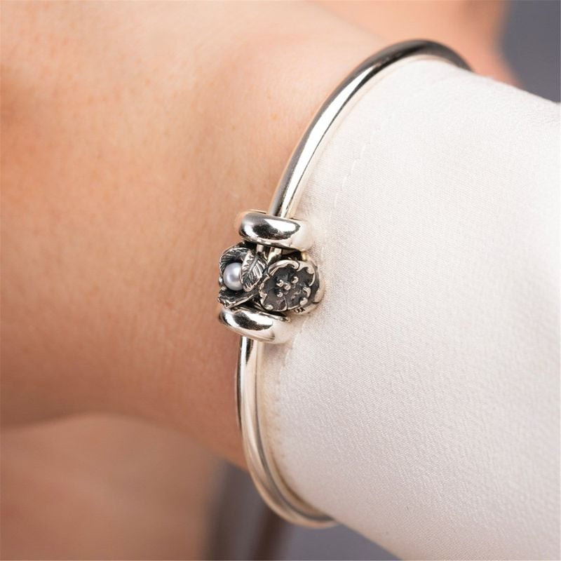 Breloque Trollbeads Nerprun de mai en argent portée sur un bracelet jonc au poignet, gros plan lifes