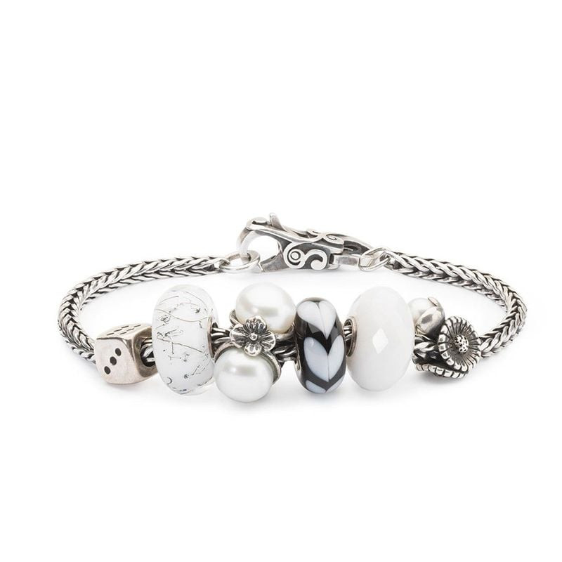 Bracelet Trollbeads orné du charm Marguerite d'avril, perles de verre blanches et noires et fermoir 