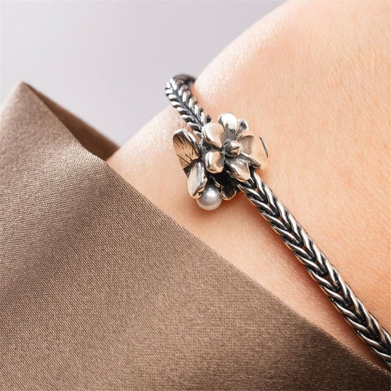 Perle Trollbeads Violette de Février avec fleur et perle de culture portée sur un bracelet en argent