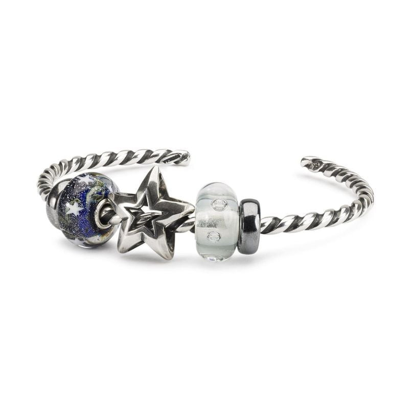 Jonc torsadé Trollbeads en argent avec perles de verre et breloque étoile en argent, fond studio bla