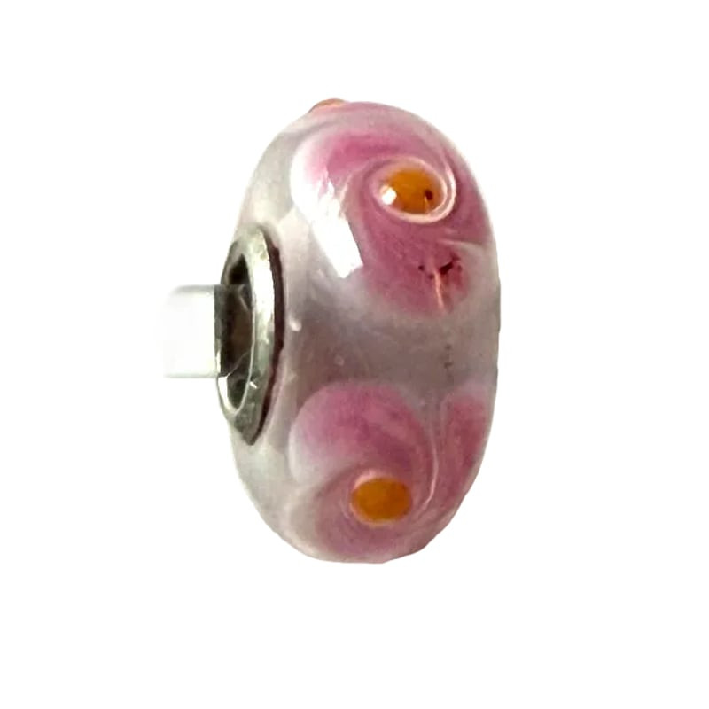 Gros plan sur la perle en verre Trollbeads Universal faite main, avec volutes roses et orange et un 