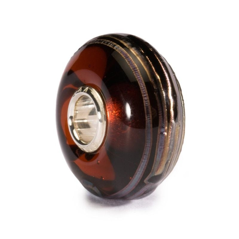 Perle Trollbeads Fil d'or en verre marron avec âme en argent sterling, vue studio inclinée sur fond 