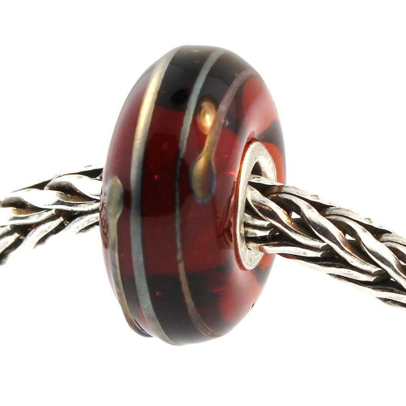 Gros plan sur la perle Trollbeads Fil d'or en verre marron sur chaîne en argent, avec fil doré et fi