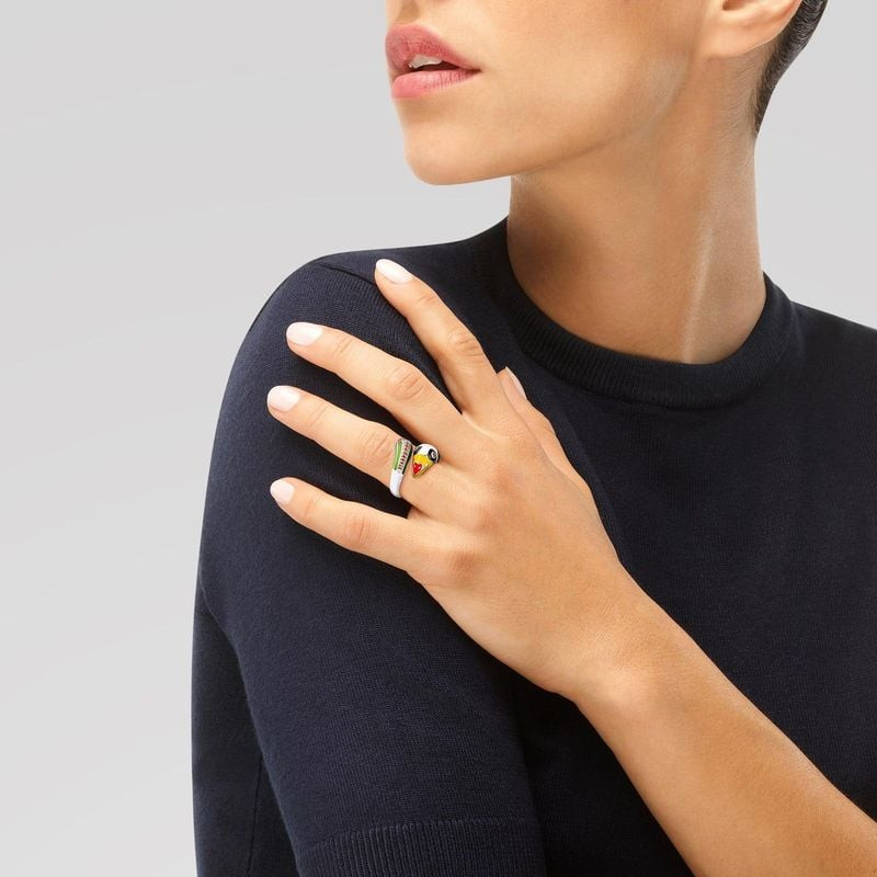 Modèle en pull en maille bleu marine portant la bague argent Toucan UNA STORIA à l'annulaire, main p