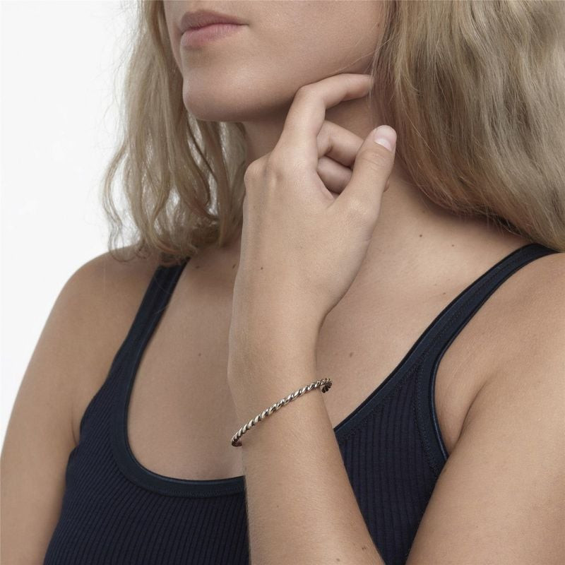 Jonc Trollbeads Lien d'Amour Torsadé Argenté porté au poignet, design torsadé en argent 925 à person