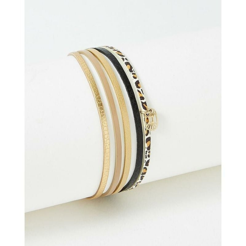 Bracelet FlowersforZoé Artiste Black Leo en acier doré et cuir, imprimé léopard, présenté sur un pré