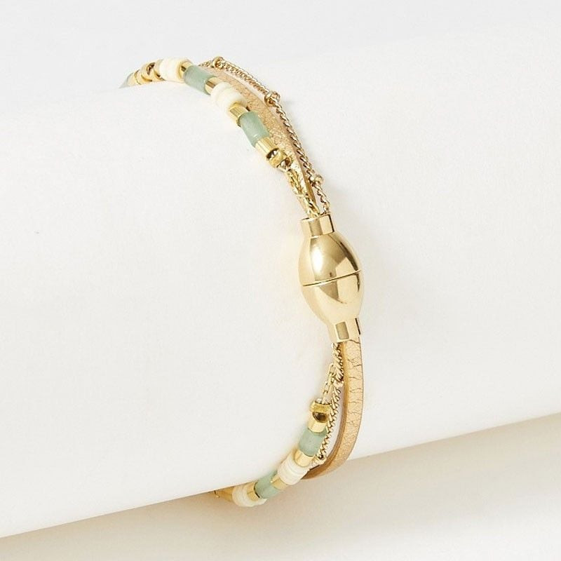 Bracelet Appoline doré vu de profil, mettant en valeur le fermoir magnétique rond et le détail en pe